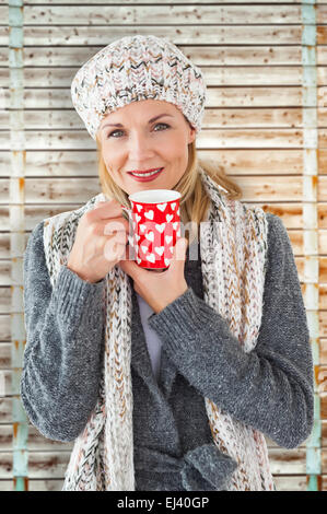 Portrait of woman in winter fashion looking at camera avec mug Banque D'Images