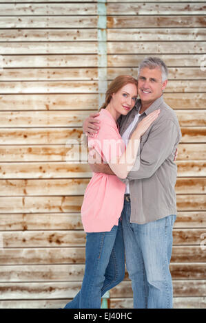 Image composite de casual couple hugging and smiling Banque D'Images