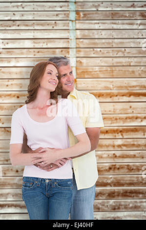 Image composite de casual couple hugging and smiling Banque D'Images