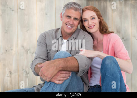 Image composite de casual couple sitting and smiling Banque D'Images