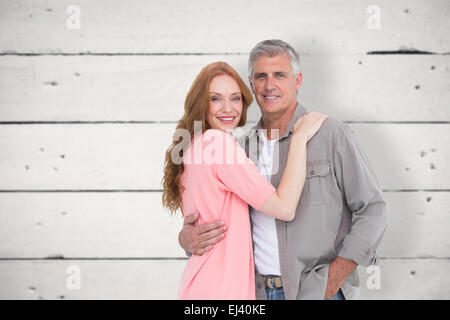 Image composite de casual couple hugging and smiling Banque D'Images