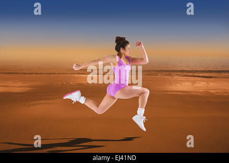 Image composite de l'ajustement brunette courir et sauter Banque D'Images