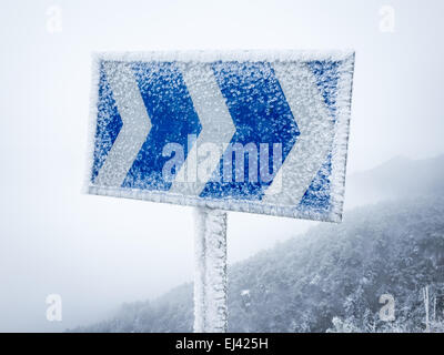 Panneau de circulation sur route de montagne en hiver Banque D'Images