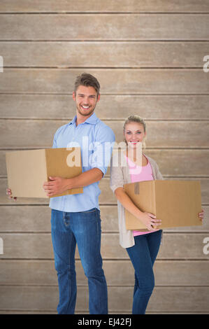 Composite image jeune couple carrying boxes Banque D'Images