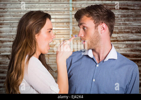 Image composite de casual young couple dans un argument Banque D'Images