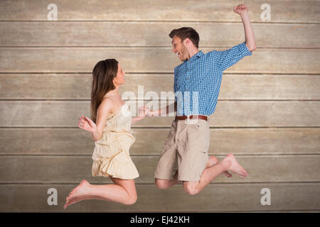 Image composite de cheerful young couple jumping Banque D'Images