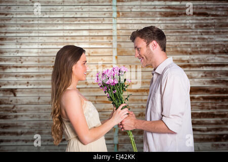 Image composite de side view of couple holding Flowers Banque D'Images