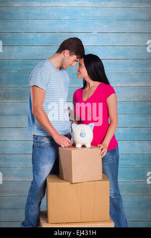 Image composite du jeune couple avec moving boxes Banque D'Images