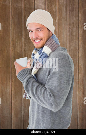 Image composite de bel homme en hiver fashion holding mug Banque D'Images