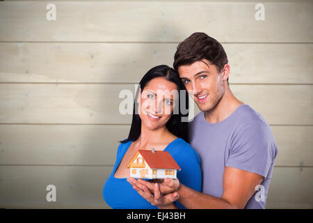 Image composite de young couple holding a model house Banque D'Images