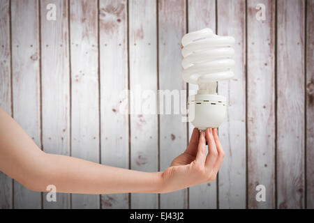 Image composite de main tenant l'ampoule écoénergétique Banque D'Images