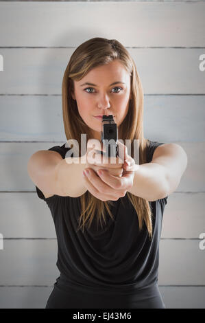 Image composite de femme fatale pointing gun at camera Banque D'Images