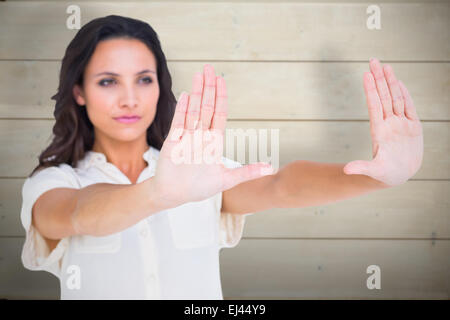 Image composite de jolie brunette holding up hands Banque D'Images