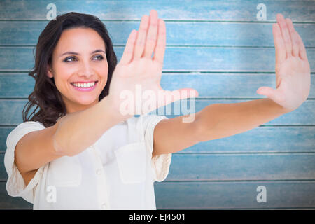 Image composite de jolie brunette holding up hands Banque D'Images