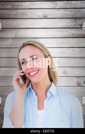 Composite image of smiling blonde au téléphone debout Banque D'Images