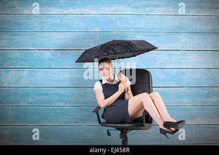 Composite image of businesswoman holding umbrella pointing Banque D'Images