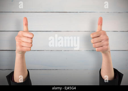 Image composite de businesswomans hands showing Thumbs up Banque D'Images