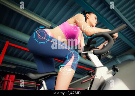 Image composite de déterminé young woman working out at spinning class Banque D'Images