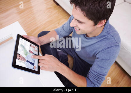 Image composite d'overhead view of man using digital tablet in living room Banque D'Images