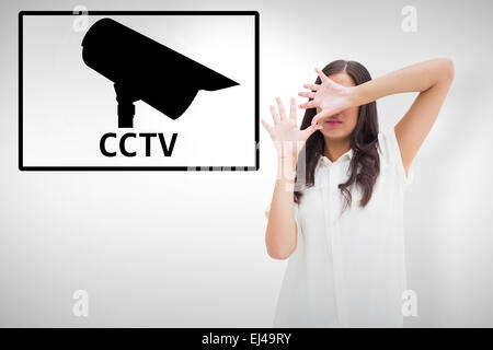 Image composite de peur brunette couvrant son visage Banque D'Images