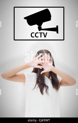 Image composite de peur brunette couvrant son visage Banque D'Images