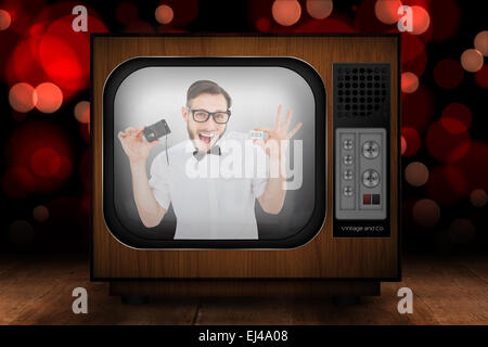 Image composite de hipster geek tenant une cassette de ruban retro player Banque D'Images