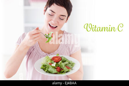 La vitamine C contre smiling woman eating salad Banque D'Images