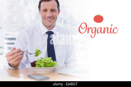 Organic contre happy businessman eating a salad sur son bureau Banque D'Images