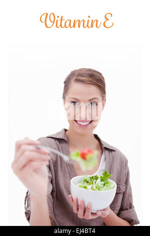 La vitamine e contre femme avec bol de salade offrant certains Banque D'Images