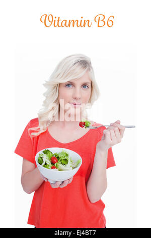 La vitamine B6 contre la jeune femme blonde manger une salade de légumes Banque D'Images