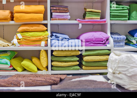 Des oreillers, des plaids, des couvertures et d'autres portent sur des étagères de chambre à coucher Banque D'Images