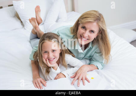 Happy mother and daughter reading a book Banque D'Images