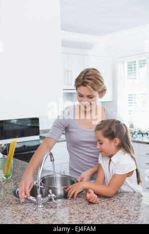 Mère et fille pot de remplissage avec de l'eau Banque D'Images