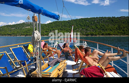 La côte dalmate, en Croatie.Les touristes se détendre et prendre un bain de soleil sur le pont supérieur d'un navire de croisière vintage en bois Banque D'Images