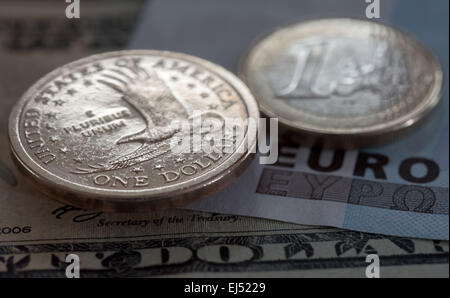 Une pièce d'un dollar américain et d'une pièce de un euro contre un dollar et un 20 20 Euro remarquedans Eichwalde, Allemagne, 21 mars 2015. Photo : Tim Brakemeier/dpa Banque D'Images