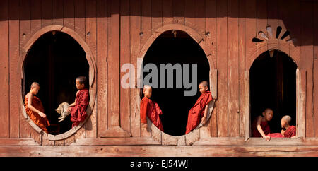 Jeunes moines bouddhistes assis dans les fenêtres; Monastère Shweyanpyay dans le village de Naung Shwe, lac Inle, Myanmar ( Birmanie ), Asie Banque D'Images