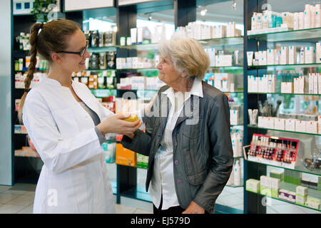 Pharmacien aide une femme senior patient reconnaissant dans la pharmacie. Banque D'Images