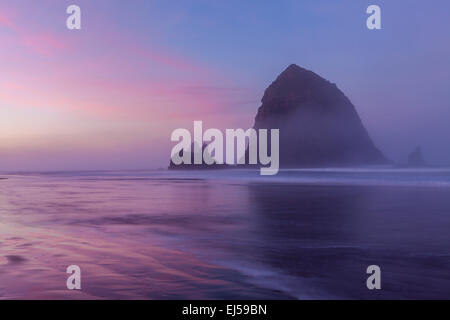 Lever du soleil au-dessus de Haystack Rock at Cannon Beach, Oregon coast, Oregon, USA. Banque D'Images