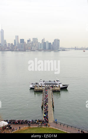 Les foules en file d'attente pour le ferry pour Manhattan, vu de la Statue de la liberté, New York City. Banque D'Images