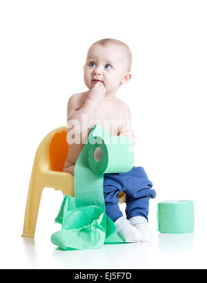 Tout-petit enfant assis sur le pot de chambre avec du papier toilette Banque D'Images