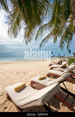 Des chaises longues sur la plage. Mui Ne, la Province de Binh Thuan, Vietnam. Banque D'Images