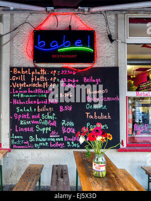 Restaurant Babel vue extérieure, panneau de menu, tables, bancs et fleurs en bouteille, Mitte, Berlin Banque D'Images