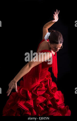 Danseuse de Flamenco habillé en rouge avec une expression du sentiment passionné à fond noir Banque D'Images