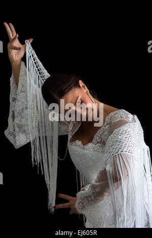 Danseuse de Flamenco vêtue de blanc avec l'expression du sentiment passionné à fond noir Banque D'Images