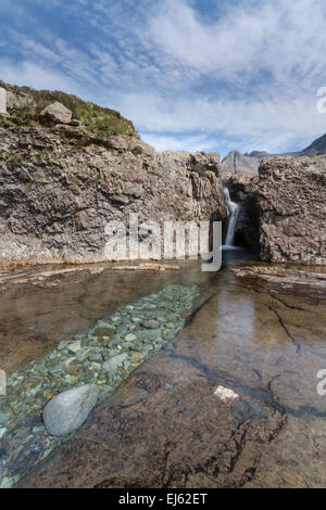 Un canal bordé de galets et de la chute d'eau entre les bassins de fées sous les montagnes Cuillin sur la magnifique île de Skye, Écosse Banque D'Images