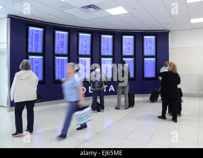 Aéroport très fréquenté, passagers afficher les tableaux des départs à l'intérieur de l'aéroport terminal de l'aéroport tout en voyageant Banque D'Images