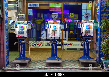 Drôle de pompes à essence avec des visages à une station-service dans la rue à Tainan, Taiwan Banque D'Images