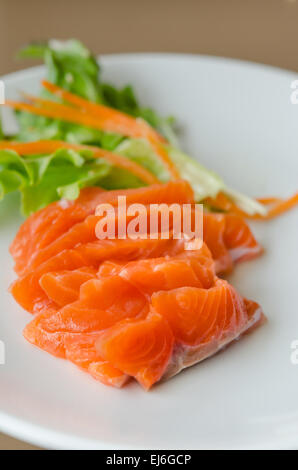 Sashimi de saumon avec salade fraîche sur le plat blanc, une cuisine de style japonais Banque D'Images