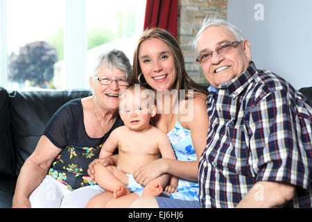 Portrait of happy young couple avec fille et sa petite-fille à l'accueil Banque D'Images