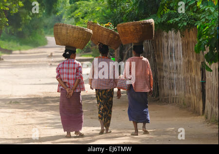 Les femmes portant des paniers sur la tête dans le village, Bagan, Mandalay, Myanmar Région Banque D'Images